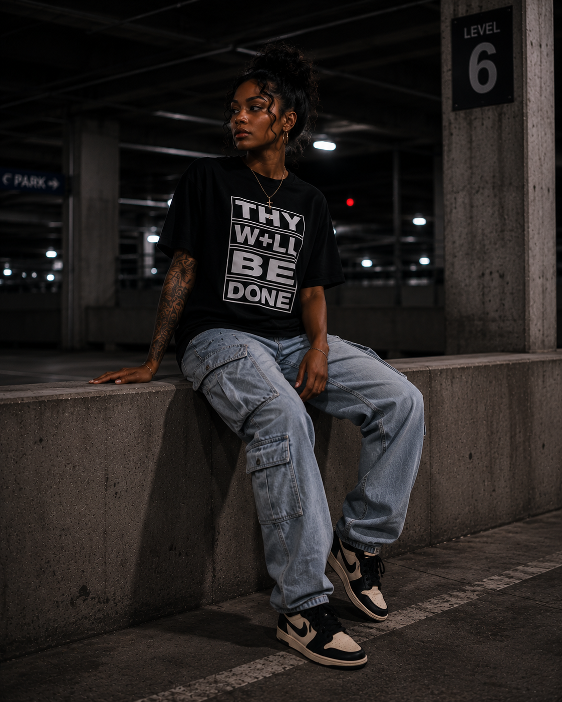 Woman seated wearing the Thy Will Be Done tee